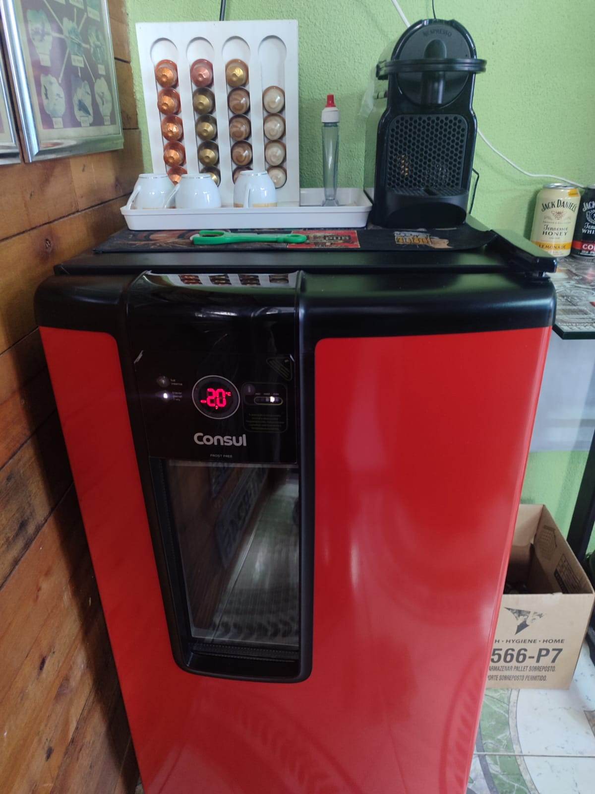 Cafeteira e cápsulas de café sobre um frigobar vermelho